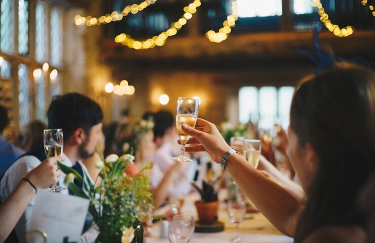 Invitați ciocnind pahare cu vin spumant la o nuntă